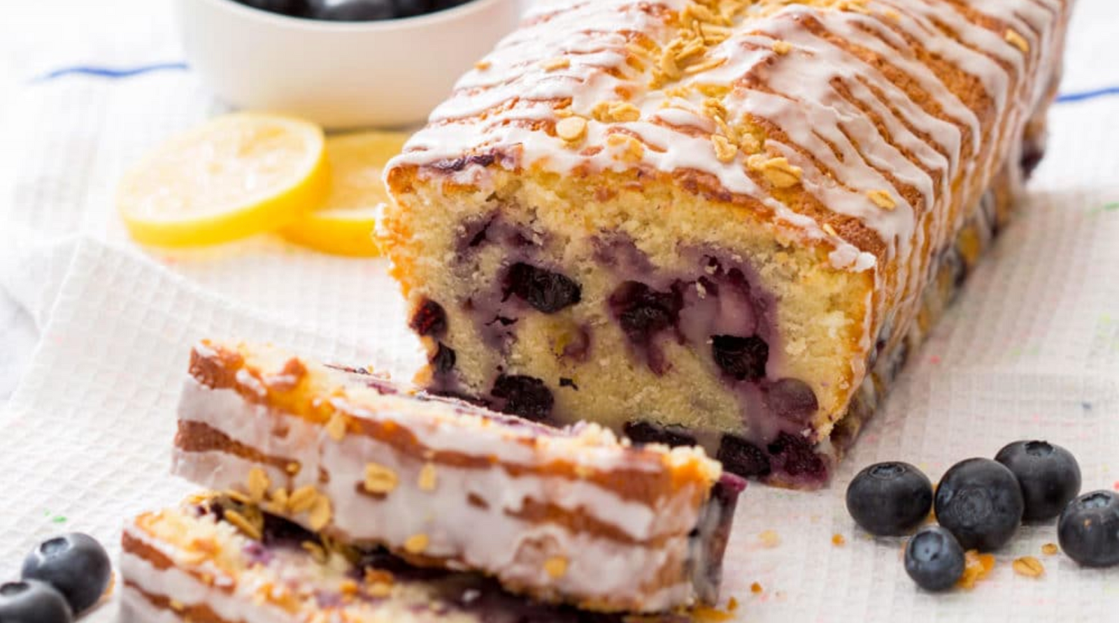 Miss Jones Baking Co Lemon Blueberry Muffin Bread with 2 slices cut and blueberries on the side